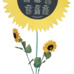 Something a little different, this seating plan is written onto a circular piece of black cartridge card with white gouache.  The black card was then set into yellow cartridge card cut into a sunflower petal shape.  This was mounted onto a green garden stick and set into a vase with some plastic sunflowers to be a freestanding seating plan at the entrance to the reception venue.